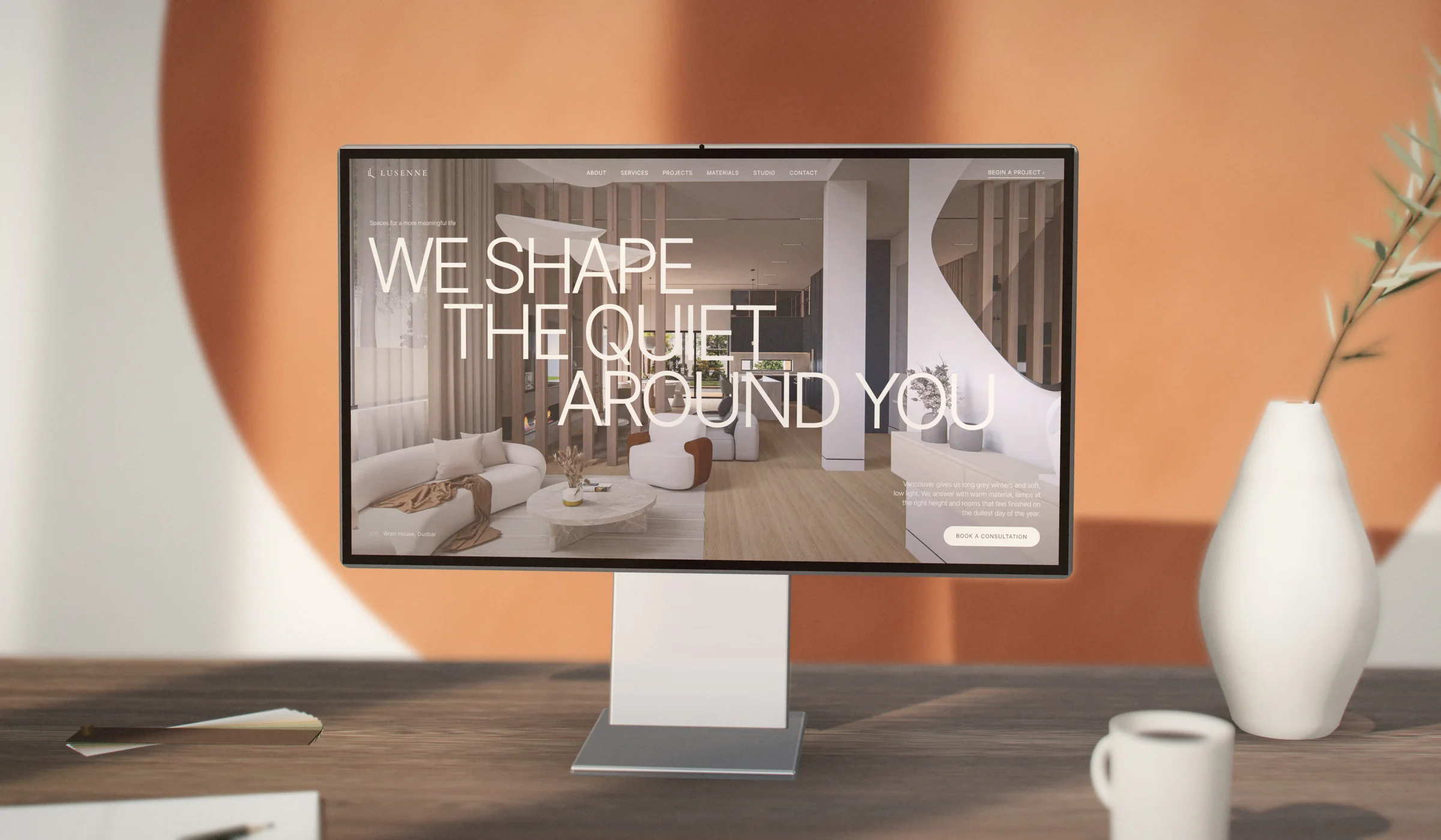 The Lusenne Interiors website on a desktop monitor against a terracotta wall